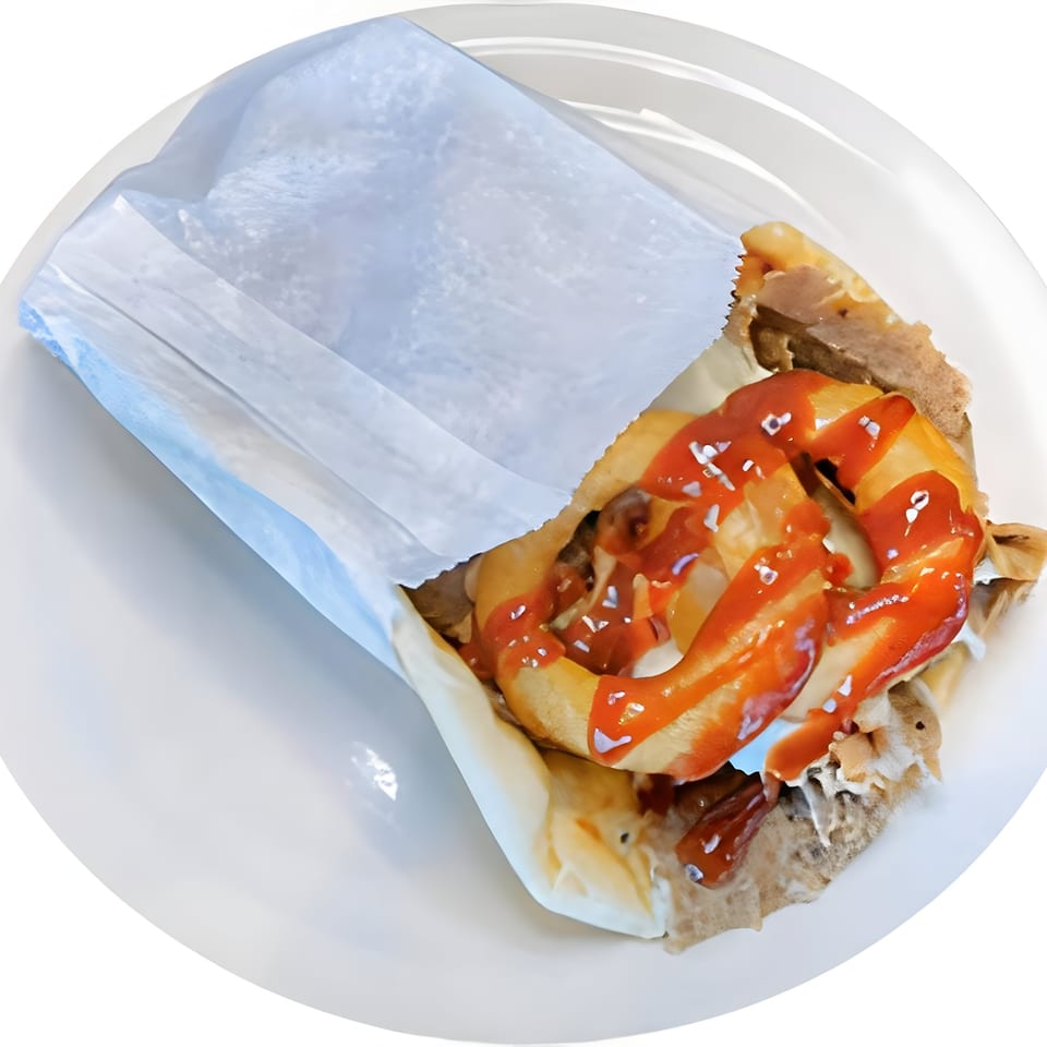 Gyro 101's gyro, wrapped in paper, topped with onion rings and red sauce.